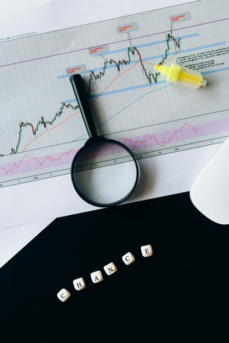 A conceptual still life of a stock chart with magnifying glass and 'chance' text.